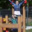Two children playing on the Fortress II playhouse with slide.
