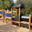 Wooden Locomotive w/ Tower and Slide train playhouse in a playground.