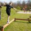 Children playing on Trim Trail Line equipment in a park.