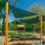 Outdoor Classroom with wooden benches, blackboard and sunshades in a green park setting.