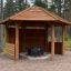 Wooden Wall to Gazebo Shelter in a forest clearing.