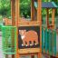 Forest Treehouse wooden playground structure with bear illustration panel and green safety barriers.