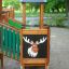 Forest Treehouse play structure with moose decoration and green railings on sandy playground