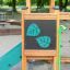 Forest Treehouse wooden playground climbing element with green leaf decorations and slide in a park 