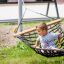Child sitting in Double Hammock (Metal) outdoors.