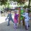 Children playing Tic Tac Toe on outdoor play equipment in a park.