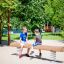 Children playing on a Balance seesaw in a sunny playground.
