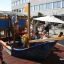 Children playing on the Small Ship sandbox in a playground.