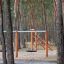 Bird Nest (âŚ€ 90 cm) Robinia Swing hanging on wooden playground frame in forest setting