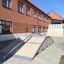 Quarter-Pipe high skateboard ramp in front of a brick building.