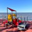 All Accessible Mars Playground with red slide and yellow climbing panel on seaside playground.