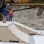 Skateboarder performing a trick on the Jump-Ramp structure with another person watching.
