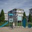 Young explorer with a climbing wall playground equipment with slide and climbing panels in an urban 