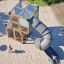 Box "Breeze" with a slide playground equipment on sandy surface with children playing