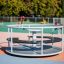 Merry-Go-Round playground equipment in a sunny park setting.