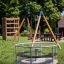 Playground Merry-Go-Round with climbing frame and swing set in the background.