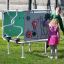 Children interacting with Sensory Box playground equipment on grass.