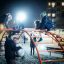 Children playing on Cross Climber steel structure at night in a playground.
