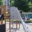 Wooden playground structure Challenger Aztec with climbing wall in a park.