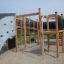 Wooden outdoor playground set Challenger Aztec with climbing net and slide.