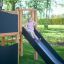 Child playing on the Little Jungle Nature play structure slide in a park