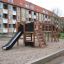 Outdoor wooden playground with slide and climbing structures, Romping Center Nature.
