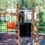 Child climbing Gorilla Nature wooden playground structure outdoors.