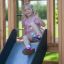 Girl playing on Gorilla Nature wooden playset with slide.