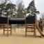 Wooden playhouse Motor Function Center Nature with climbing structures and slide in an outdoor playg