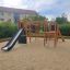 Playground structure Challenger Nature with slide and climbing frames in a sandy area.