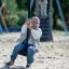 Silver Cableway playground zip line with child sliding on sandy surface