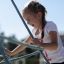 a girl playing on the outdoor rope playground