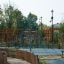 Powerclimber climbing net in a playground surrounded by a wooden fence.