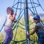 girls climbing a net tower on the outdoor playground