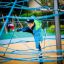 a boy climbing a rope tower on the playground