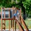 A child playing on Square Play Nature climbing structure in a park.
