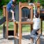 Children playing on the Square Play Nature wooden playground structure.