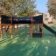 Square Play Nature playground equipment with a slide and climbing structure in a park.