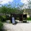 Playground equipment 'Square Play Nature' with slide and climbing structure in a garden setting.