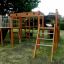 Square Play Nature playground structure with ladders and slide in a residential backyard.