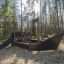 a black wooden playground ship in the forest