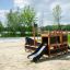 Small Ship Sandpit black playground equipment with slide on sandy surface