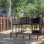 Playground structure King-Kong Nature II castle with slide, climbing wall, and bridge.