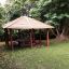 Wooden Firehouse playground gazebo in a green park setting.