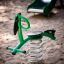 Bird swing rocking toy on a sandy playground.