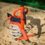 Bird swing rocking playground equipment on sandy surface'