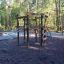 Sherwood wooden playhouse on a playground surrounded by trees.