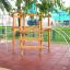 Wooden Sherwood playhouse in a playground with climbing bars.