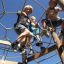 Children playing on Sherwood wooden playhouse climbing structure.