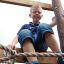 Boy climbing Sherwood wooden playhouse.